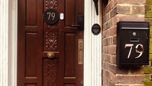 A brown door with a number plate '79' and a mailbox with the same number. - London Central 4Bed House with Garden (London)