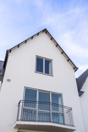 Ein zweistöckiges Gebäude mit Balkon und Fenster.