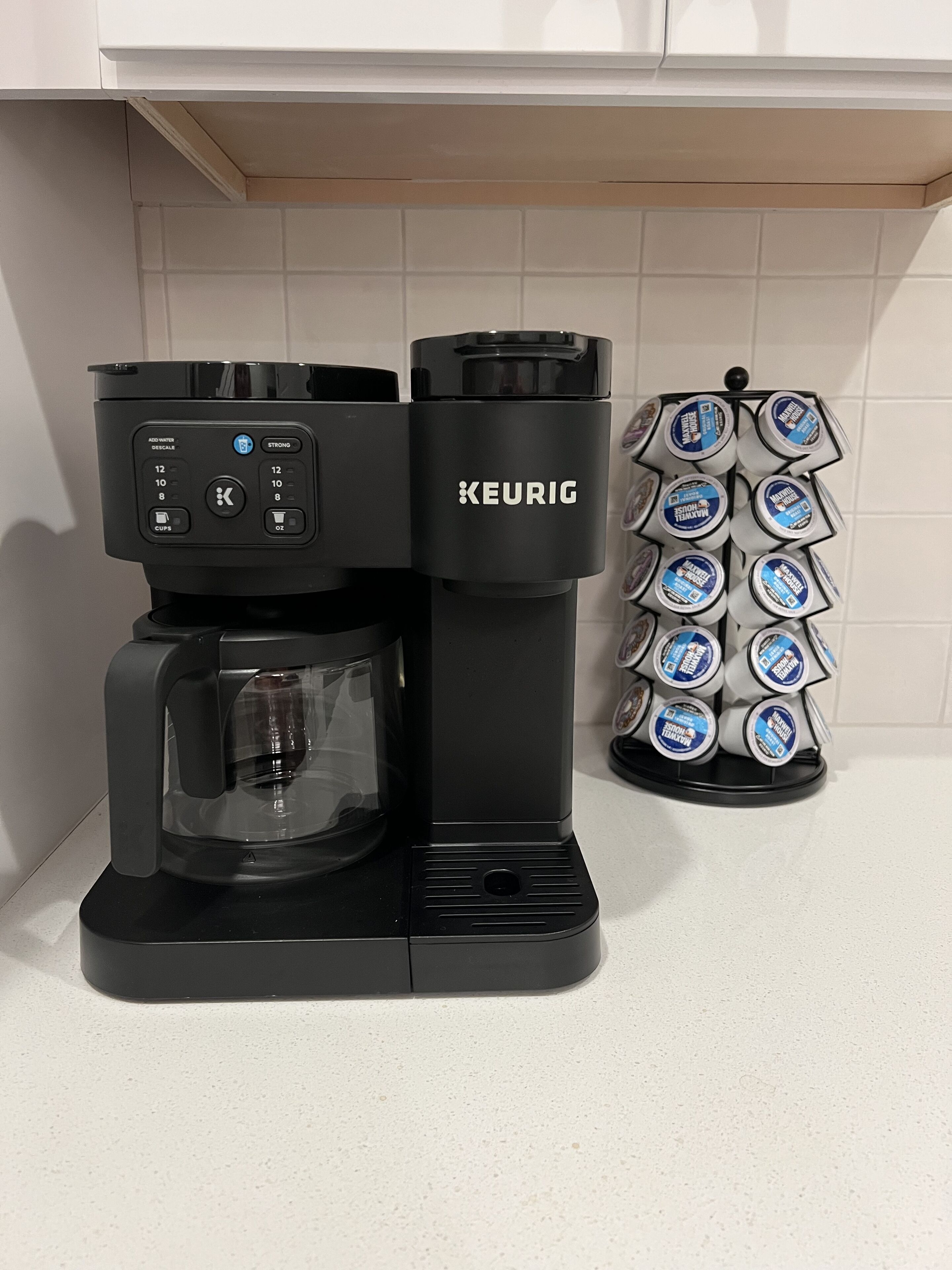Een Keurig koffiezetapparaat met een houder voor koffiecups op het aanrecht.
