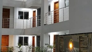 A multi-story building with balconies, potted plants, and a sign for 'LYN MACK SUITES'. - Luxurious & Exclusively furnished Suite -UN Blue Zone, Child Friendly Apt. (Nairobi)