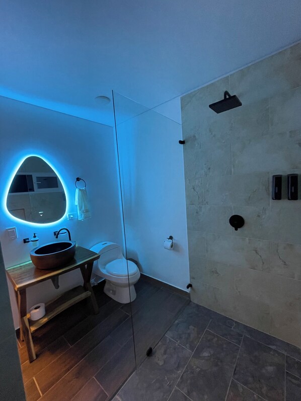 A modern bathroom with a round mirror, a sink, and a toilet. - Tropical Paradise, Deluxe duplex cabin nestled in the majesty of the mountains (Anapoima)
