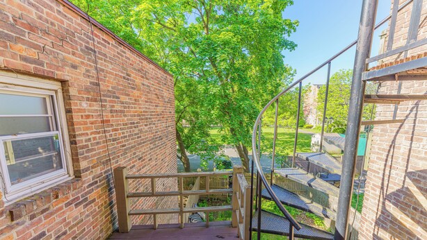A brick building with a wooden staircase leading to a deck area. - Massive 5BD/4BA 3-Story Duplex @ Downtown Albany (Albany)