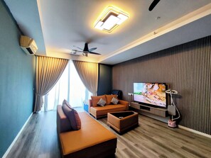 A modern living room with a sofa, ottoman, and a flat-screen TV. - 4Rooms7beds4bath - Kuala Lumpur, Malaysia (Petaling Jaya)