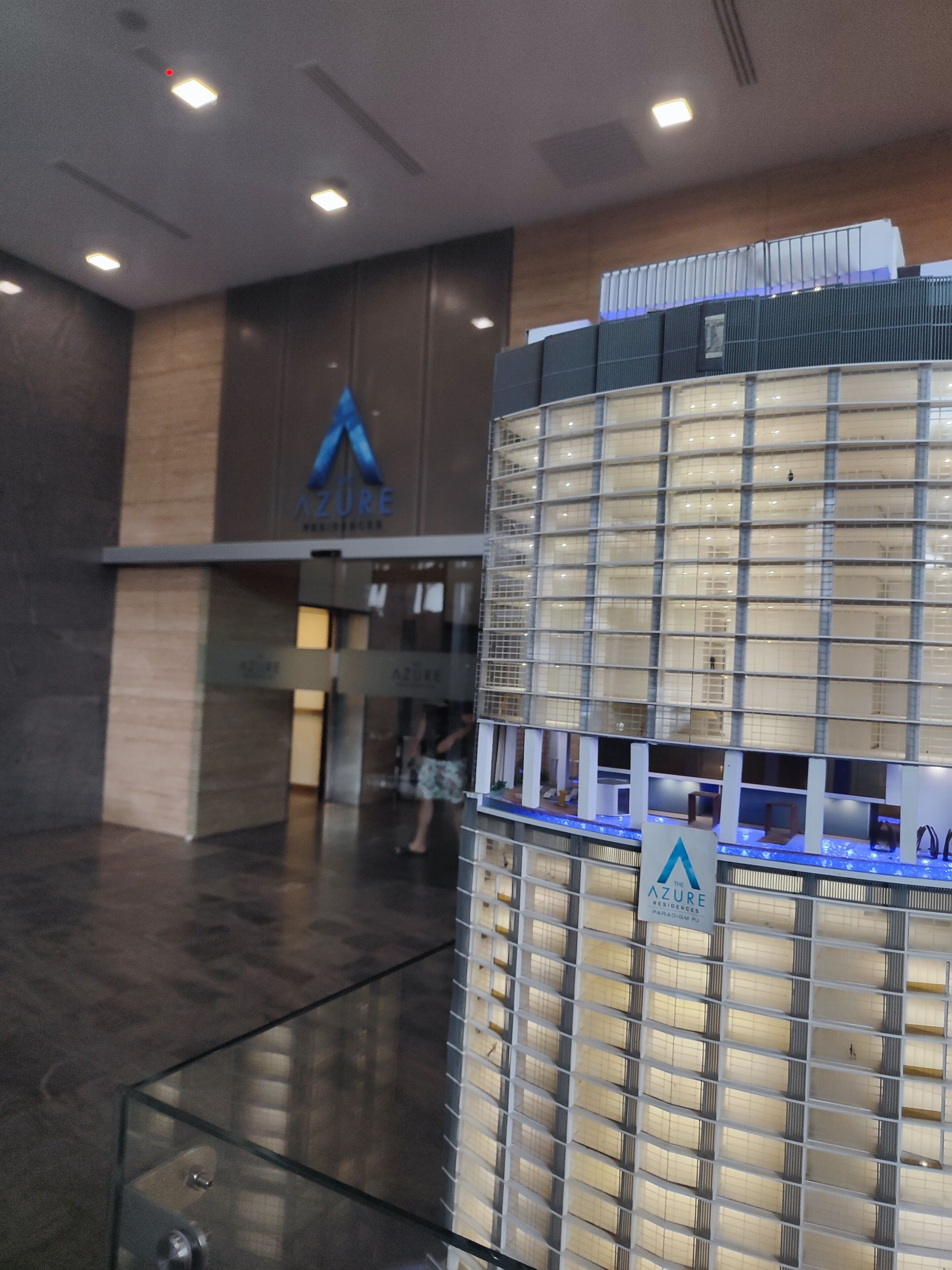 A modern building with a glass facade and a sign that reads 'Azure Residences.'