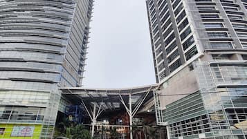 Two modern high-rise buildings with a central atrium and surrounding greenery.