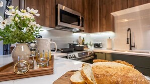 Eine Küche mit Holztischplatte, Brot und einer Vase mit Blumen.