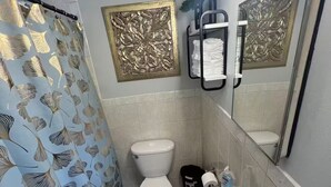 Un bagno con WC, lavandino e tenda doccia.