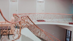 A spacious interior with a curved staircase, a seating area, and a door in the background. - Emporis Resort  (Arouca)