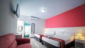 A hotel room with two beds, a red couch, a TV mounted on the wall, and a window with a view of the outside. - Emporis Resort  (Arouca)
