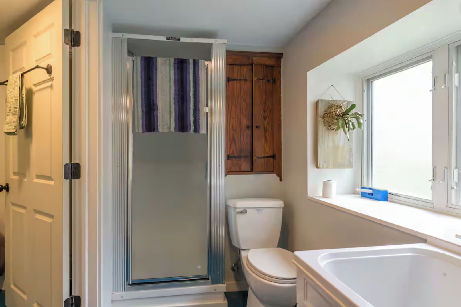 Une salle de bain avec douche, toilettes et baignoire.