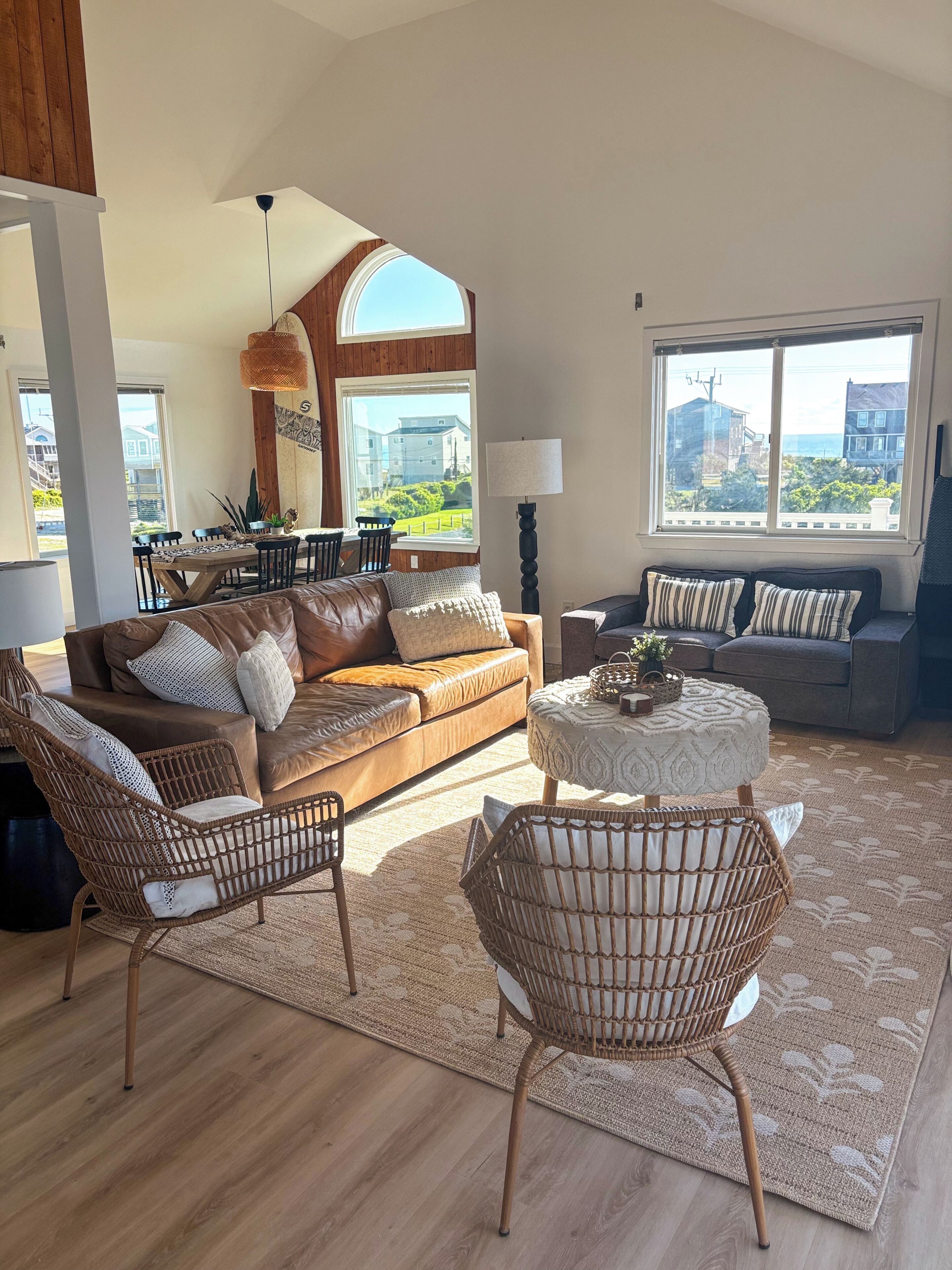 A spacious living room with a large window, a dining area, and a cozy seating arrangement.