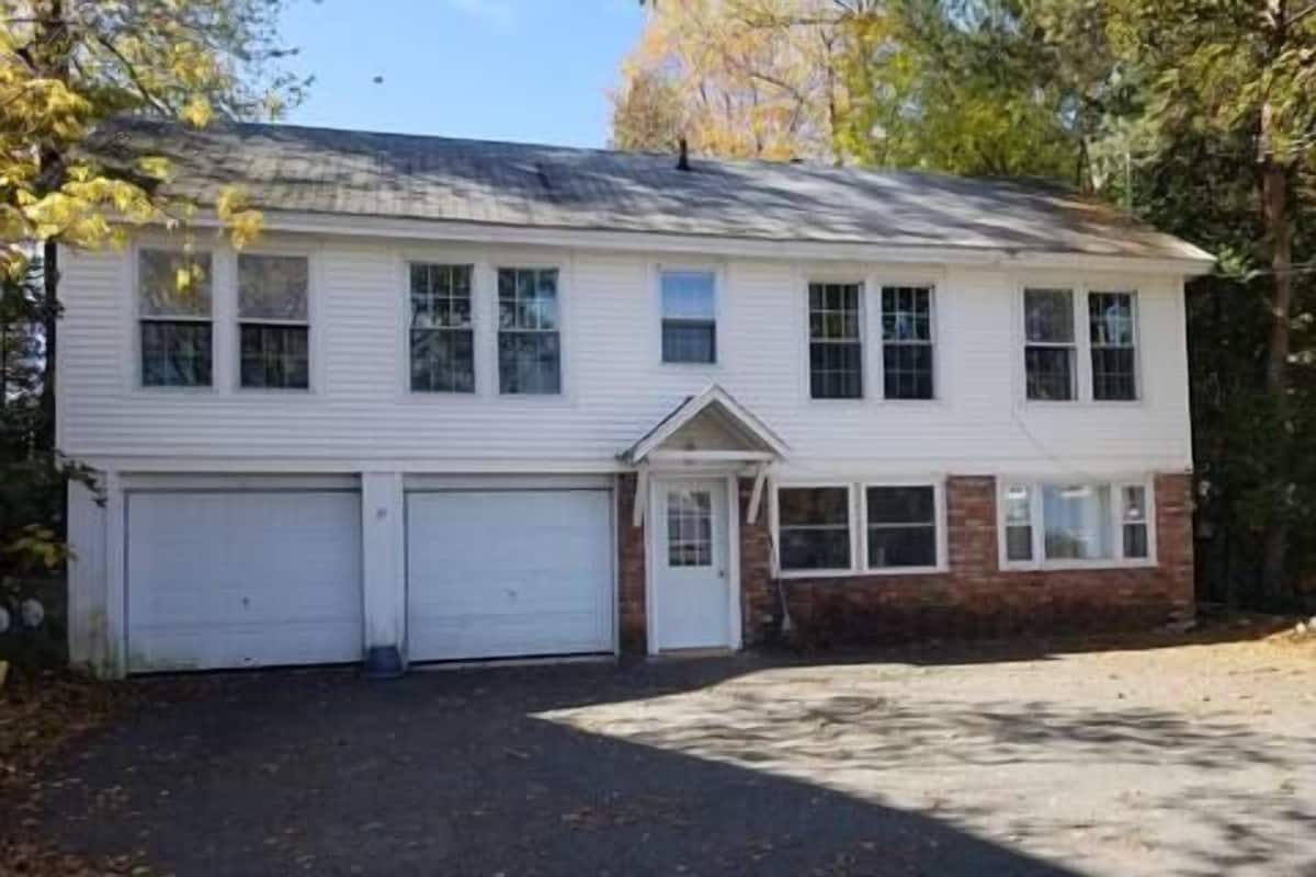 A two-story house with a garage, a front porch, and a driveway.