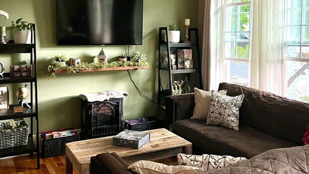 Ein gemütliches Wohnzimmer mit Flachbildfernseher, Kamin, Sofa und Couchtisch.