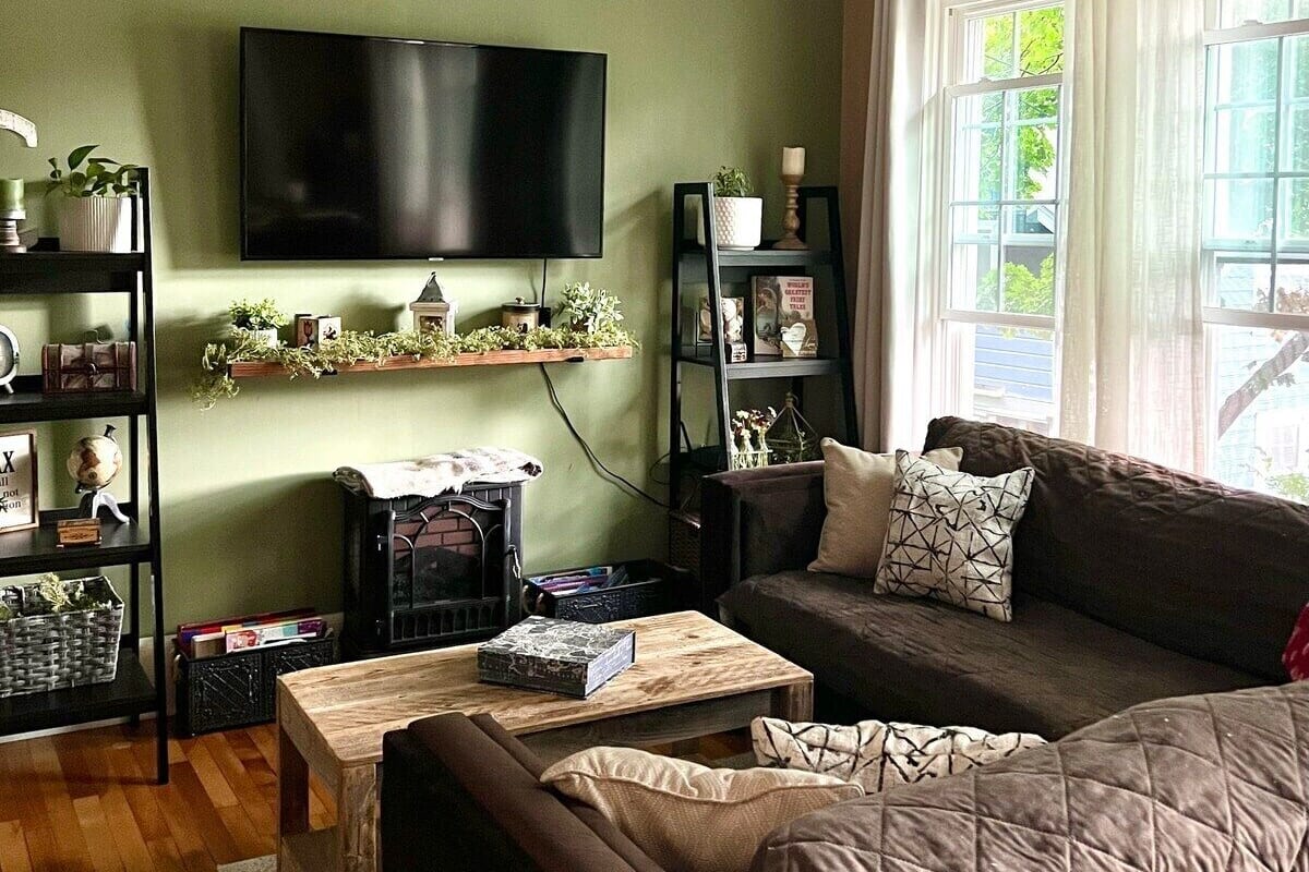 A cozy living room with a flat-screen TV, a fireplace, a sofa, and a coffee table.