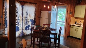 A cozy cabin interior with a dining area, wooden ceiling, and a view of the outdoors. - Charming 2-bedroom  lakefront cabin in delightful Phillip,WI (Phillips)