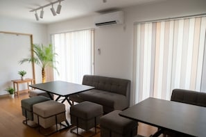 A room with a sofa, two tables, and a small plant. - SANTE 4073 STAY & SAUNA HAKATA ISLAND 1 (Imabari)