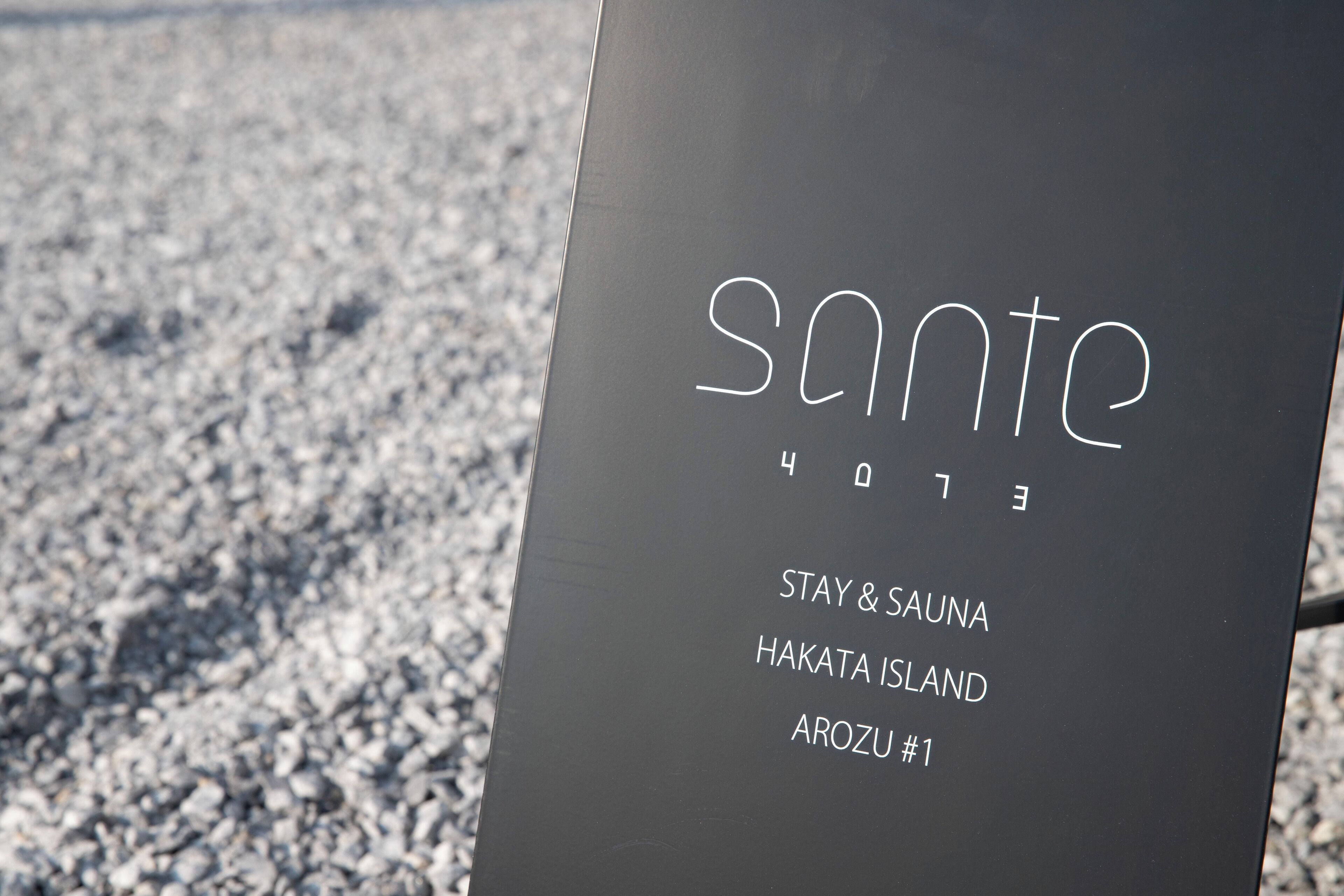 A sign with the text "sante" and "STAY & SAUNA HAKATA ISLAND AROZU #1".