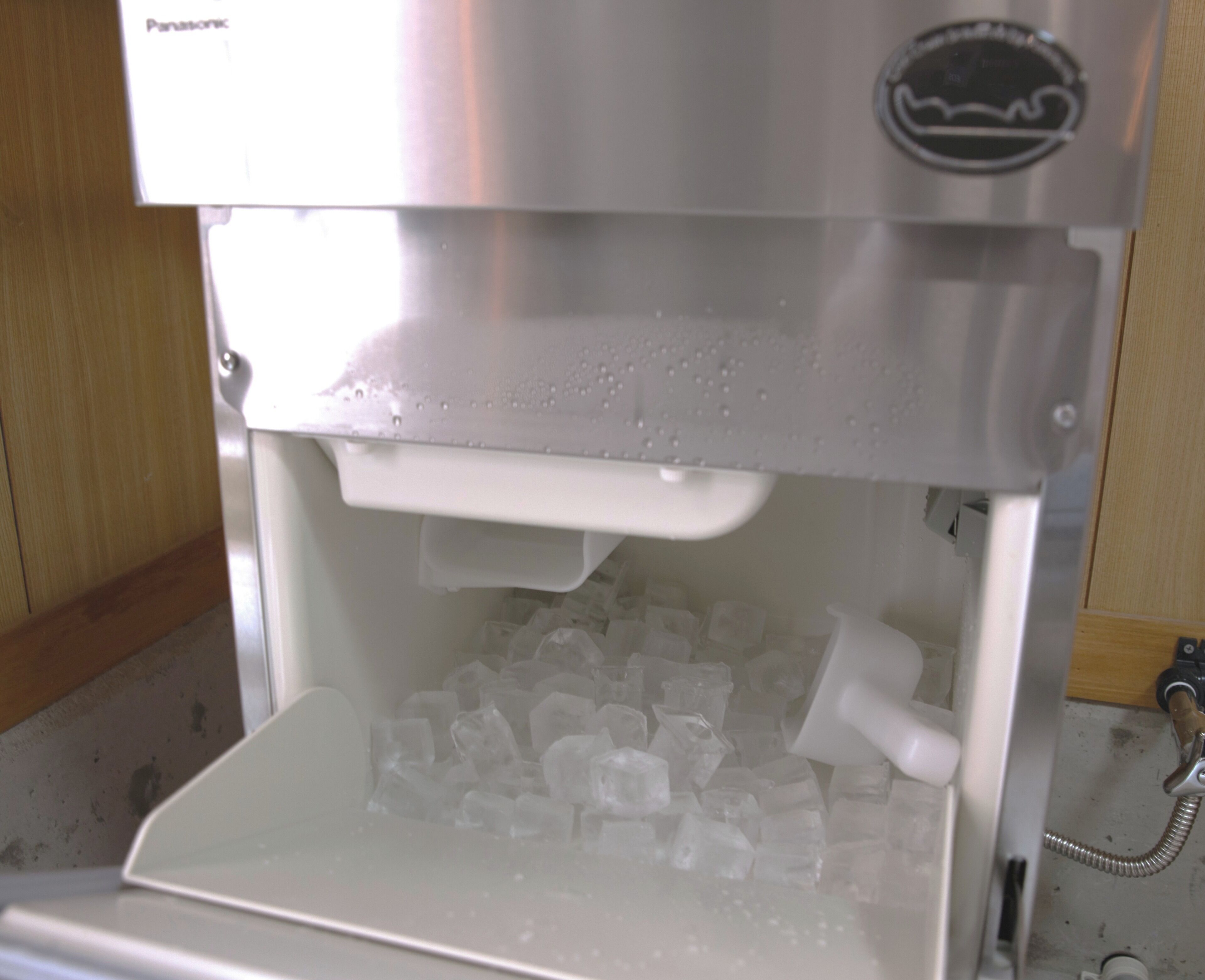 A beverage dispenser with a clear container filled with ice cubes.