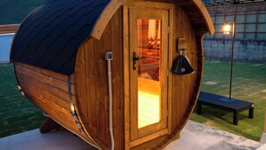 A wooden barrel-shaped structure with a door, a bench, and a light fixture outside. - SANTE 4073 STAY & SAUNA HAKATA ISLAND 1 (Imabari)