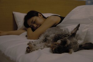A person sleeping in a bed with a dog beside them. - SANTE 4073 STAY & SAUNA HAKATA ISLAND 1 (Imabari)