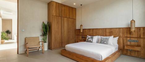 Camera da letto moderna con struttura letto e armadio in legno, una panca e un lampadario.