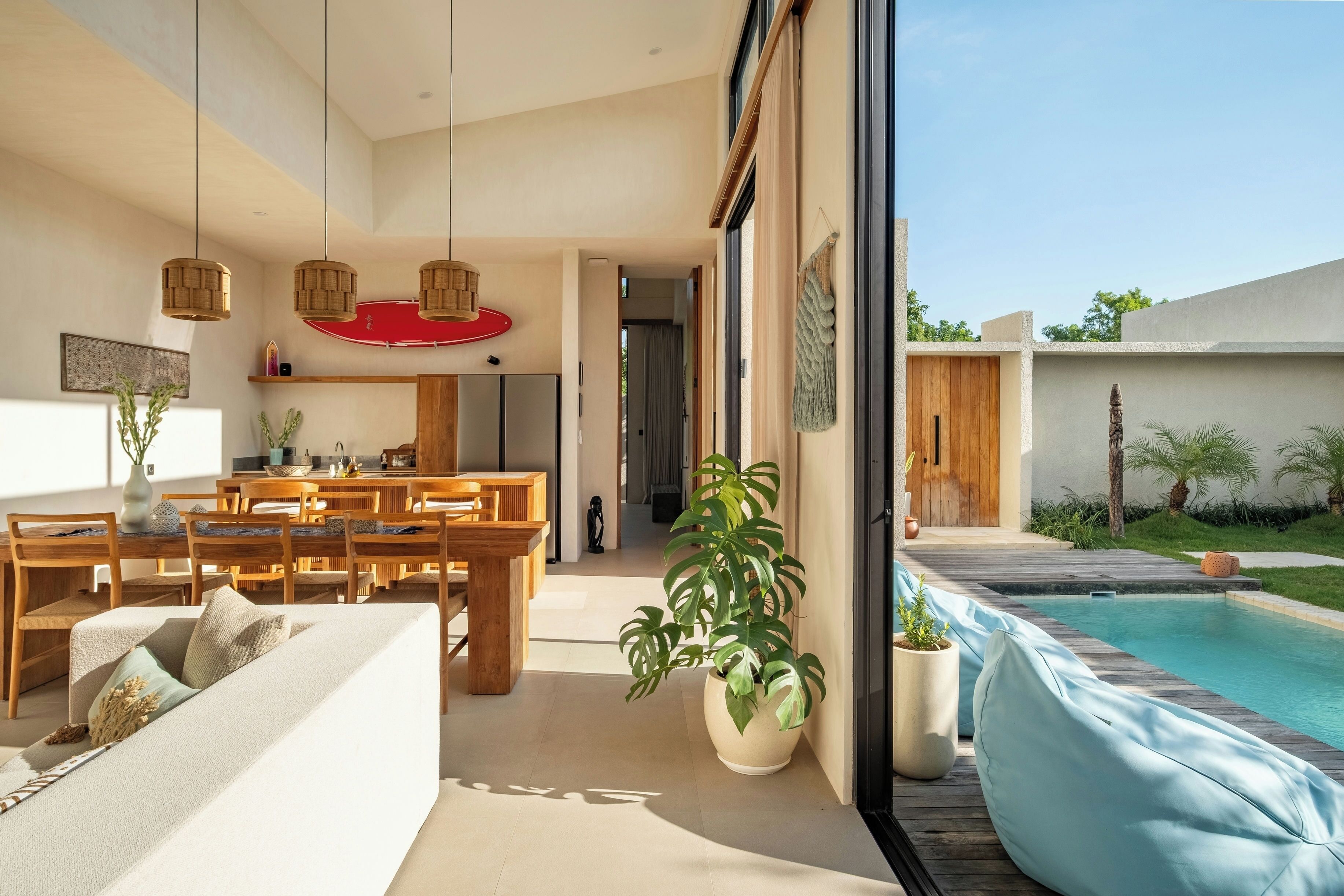 A modern interior with a dining area, a pool, and a view of the outdoors.