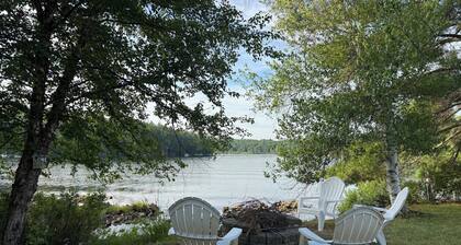 Stunning lakefront home with a boathouse, private dock, firepit and lake views