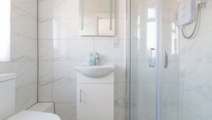 Un bagno moderno con WC, lavabo e cabina doccia in vetro.