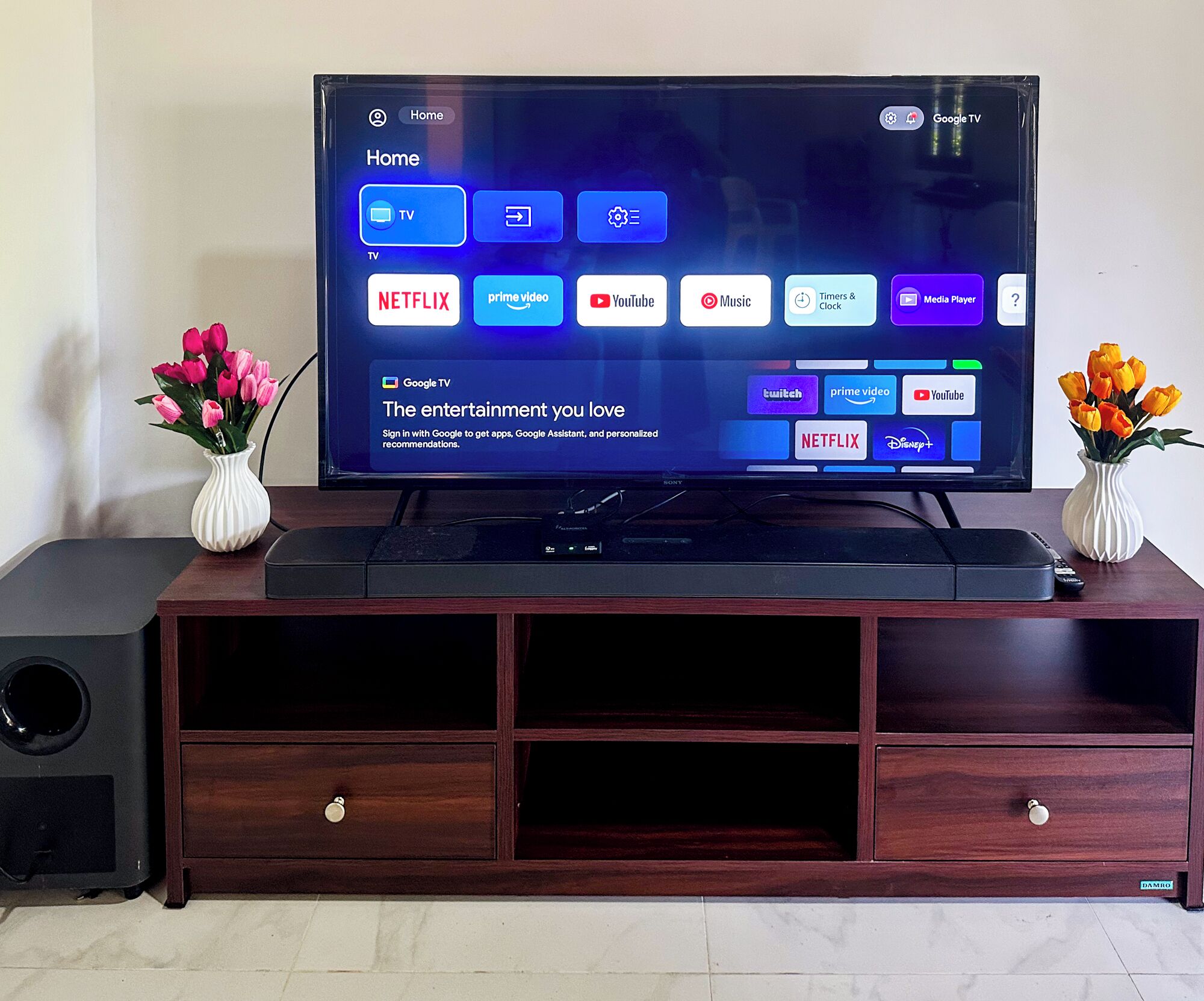 A flat-screen TV on a wooden entertainment center with a remote control on top.