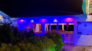 Un bâtiment doté d’un espace extérieur abrité, de nombreuses fenêtres et d’une porte bien visible.