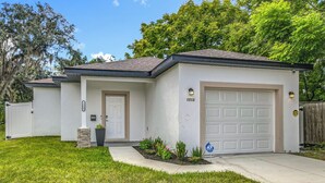 A single-story house with a white exterior, a garage door, and a front yard with a small garden. - Getaways, your way!
Spacious & Modern 3BR, 2BA (Sanford)