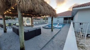 A pool area with lounge chairs, a thatched gazebo, and a swimming pool. - 9BR/5BA/Pool/Jacuzzi/Theater/Mini Golf/Beach (Pompano Beach)