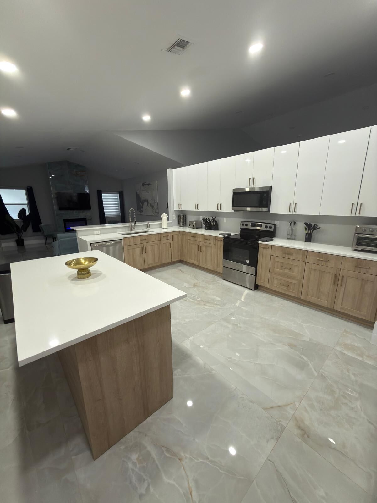 Una cocina moderna con armarios blancos, una isla central y electrodomésticos de acero inoxidable.
