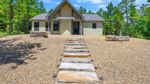 A two-story house with a stone pathway leading to the front door. - Couples Escape w/ Hot Tub•Firepit •Trail Access (Broken Bow)