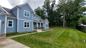 A two-story house with a front garage, a covered porch, and a well-maintained lawn.