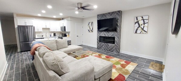 A modern kitchen with white cabinets, a built-in oven, and a microwave.