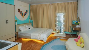 A bedroom with a bed, a desk, a chair, a mirror, and a bathroom. - Alula Ha Noi Homestay (Hanoi)