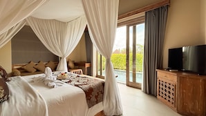 A bedroom with a large bed, a television, and a view of a swimming pool. - Dlobong Private Pool Villa Ubud (Sukawati)