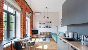 Una cocina moderna con comedor, televisor y sofá.