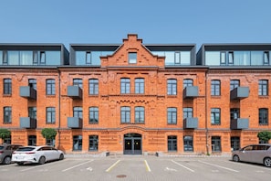 A multi-story building with a brick facade, large windows, and a central entrance.