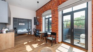 Un apartamento moderno con cocina, comedor y un dormitorio con ventana grande.