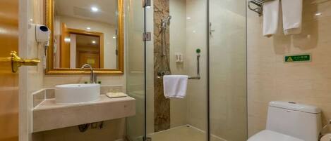 A modern bathroom with a glass-enclosed shower, a white sink, and a toilet.