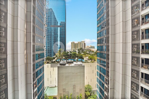 A view of tall buildings with a central structure featuring a flat roof and multiple windows.