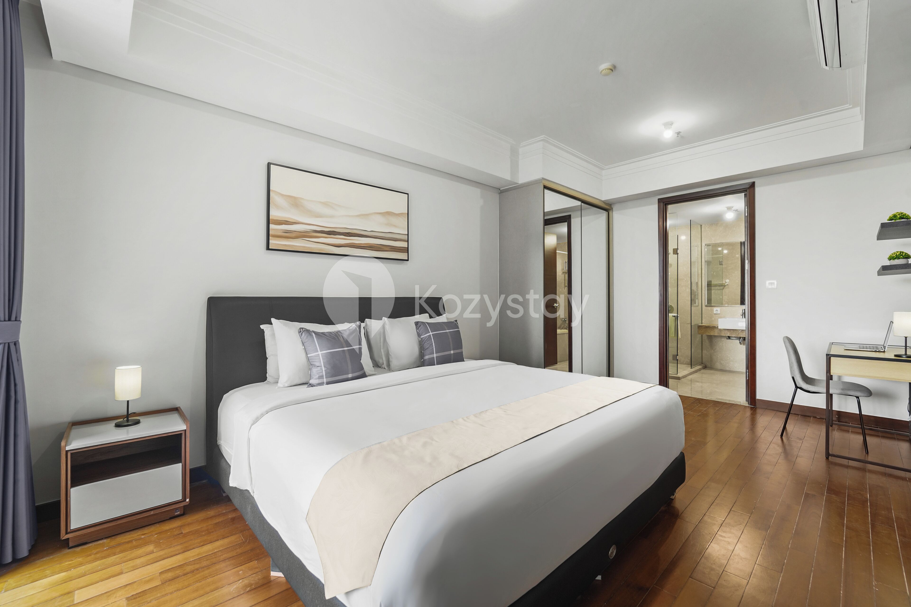 Une chambre d’hôtel moderne avec un grand lit, une table de chevet et un bureau avec une chaise.