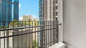 Un balcón con barandilla metálica que ofrece vistas a un paisaje urbano con edificios altos.