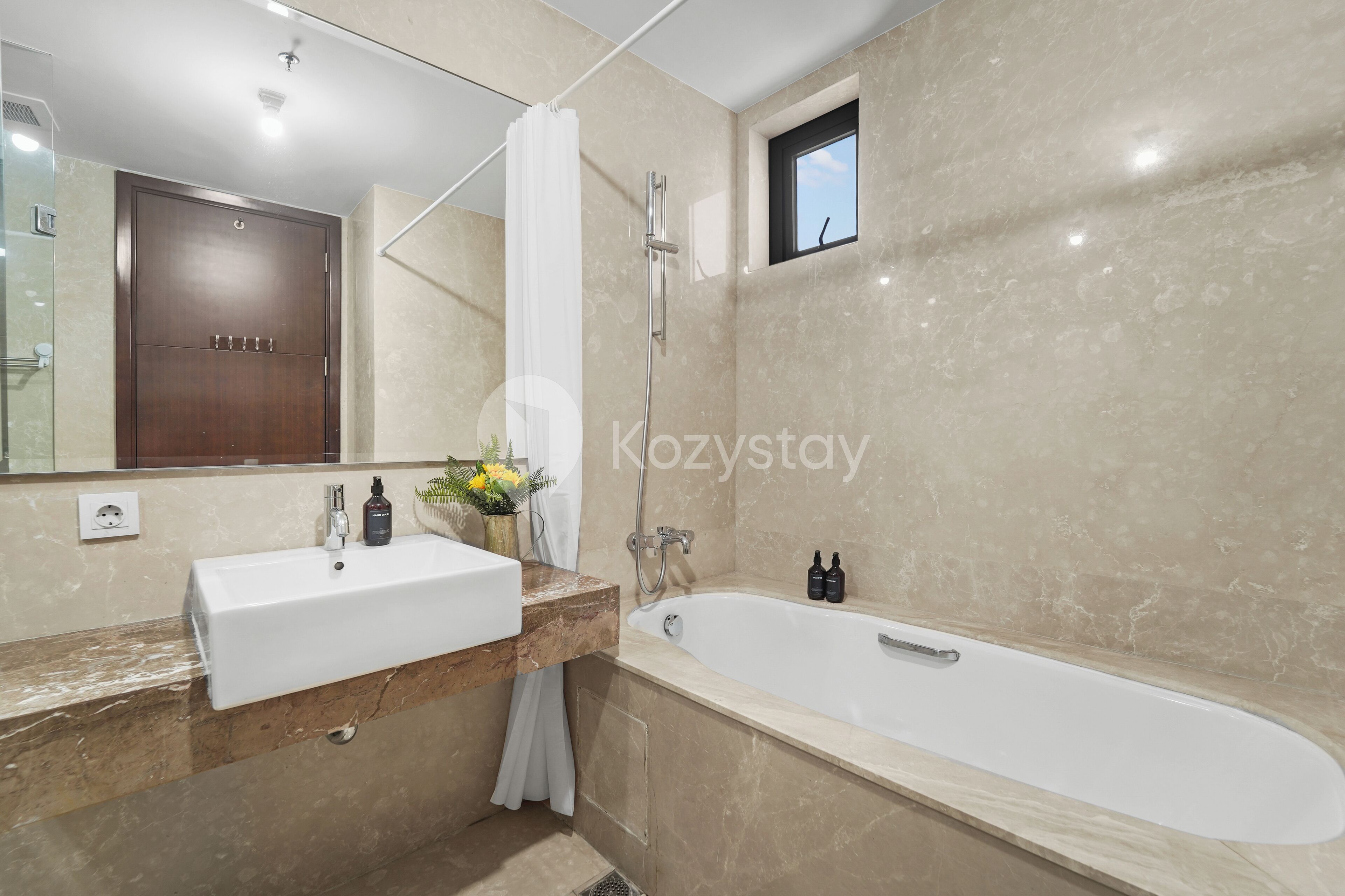 A modern bathroom with a large mirror, two sinks, a bathtub, and a shower.