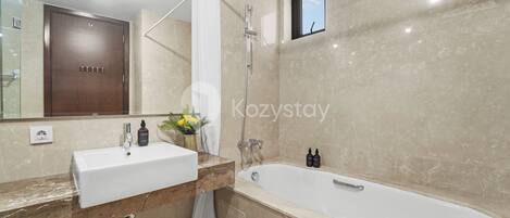 A modern bathroom with a large mirror, two sinks, a bathtub, and a shower.