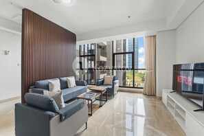 A modern living room with a sofa set, a coffee table, and a TV. - Sivori by Kozystay - Kuningan (Jakarta)