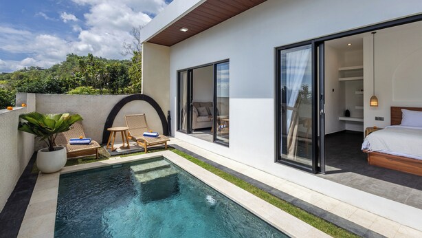 A modern hotel room with a large sliding glass door leading to a balcony with a pool. - Oceanview Escape 1BR Villa Bingin, Uluwatu (Bali)