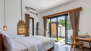 A bedroom with a bed, a desk, and a view of the outdoors. - Oceanview Escape 1BR Villa Bingin, Uluwatu (Bali)